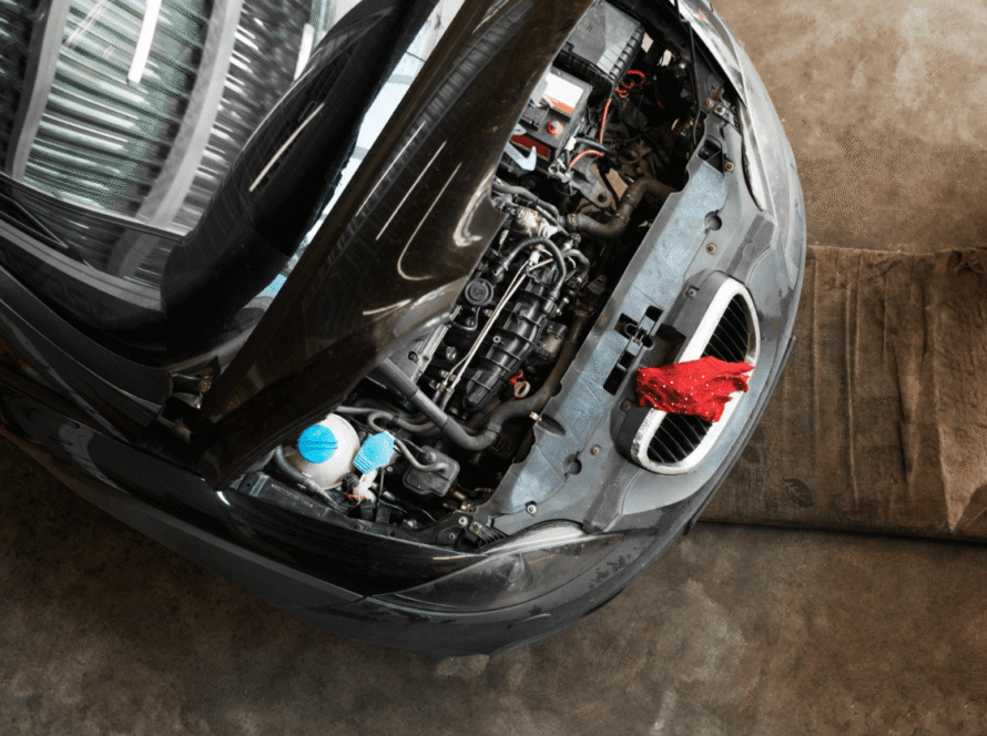 Atidarytas automobilio variklis atliekant variklio diagnostikos ir remonto darbus autoservise.